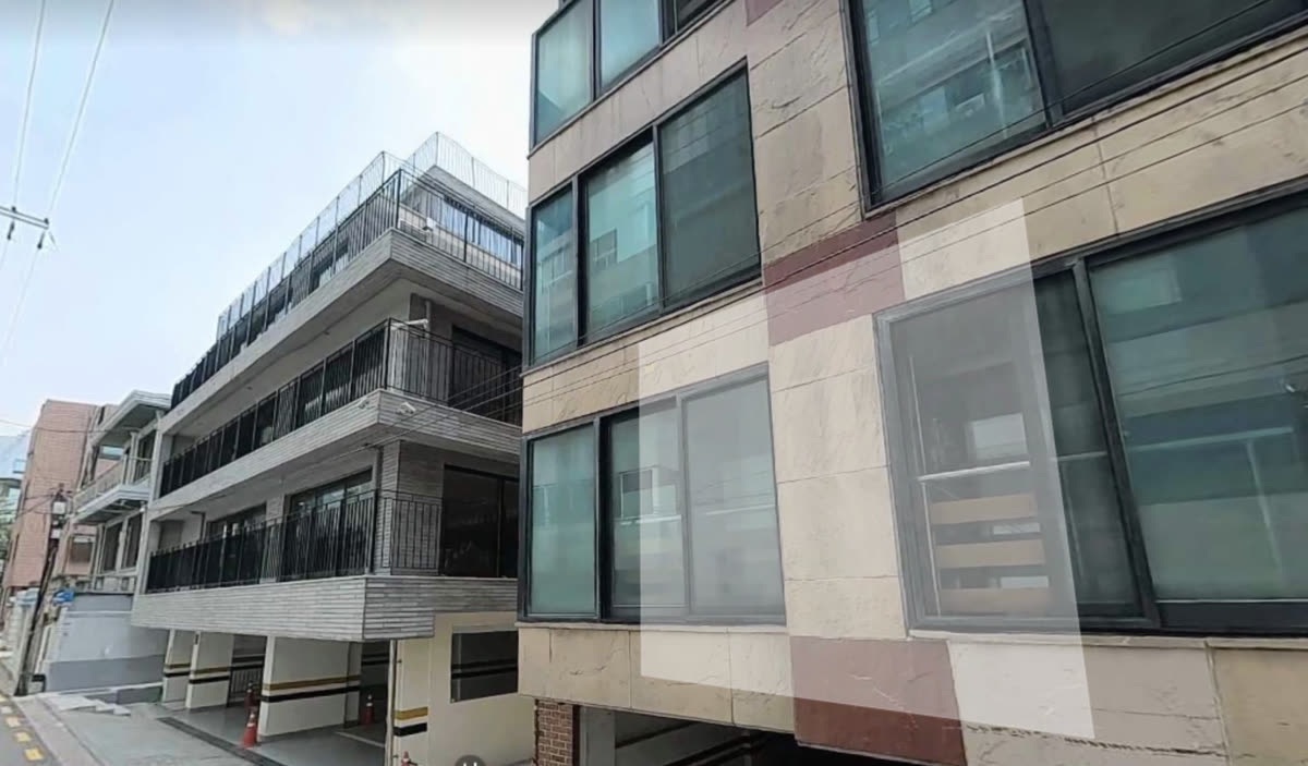흰 벽돌에 검은 난간이 있는 역삼836 건물 외관, 1층은 필로티 주차장